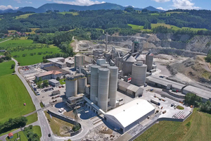 1 In front, the new packing hall and the four loading-area silo towers