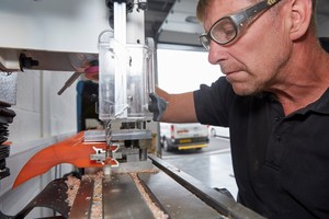 1 A technician mills a belt cleaner blade prior to installation